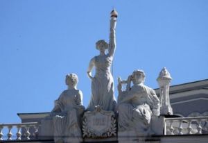 На фоне голубого неба скульптуры трех муз искусства.