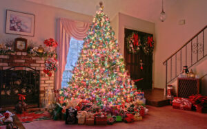рождественская елка с подарками рядом с камином