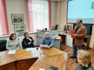 две женщины и один мужчина сидят за столом на мероприятии