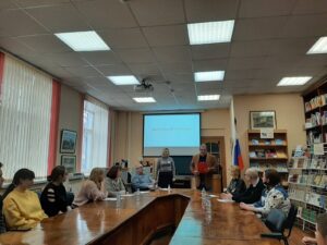 люди сидят за столом и слушают ведущих