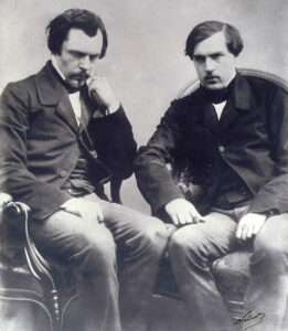 двое мужчин во фраках сидят на стульях