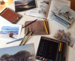 книги с рисунками, краски, карандаши на столе