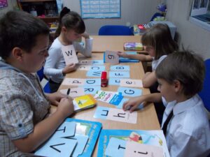 дети раскладывают английского алфавита и изучают иностранный язык