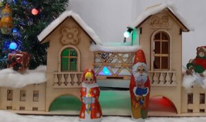 Снегурочка и Дед Мороз на фоне домика. Снегурочка подберет книги