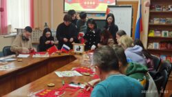 Гости мероприятия изготавливают красные китайские фонарики