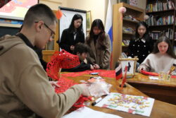 Китайские студенты делают красные фонарики на мероприятии «Символы китайского календаря»