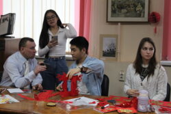 Русские и китайские ребята изготавливают красные фонарики на мероприятии «Символы китайского календаря»