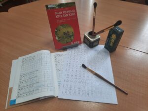 книга с китайскими иероглифами, кисть и тушь для письма. китайский язык