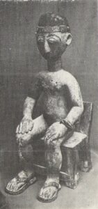 Деревянная фигура сидящего на стуле мужчины