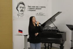 Девушка с микрофоном рядом с роялем