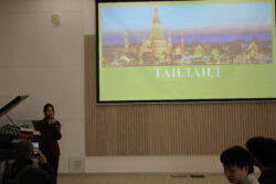 Девушка рядом с экраном с презентацией о Тайланде