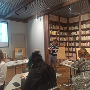 лектор демонстрирует картину перед публикой