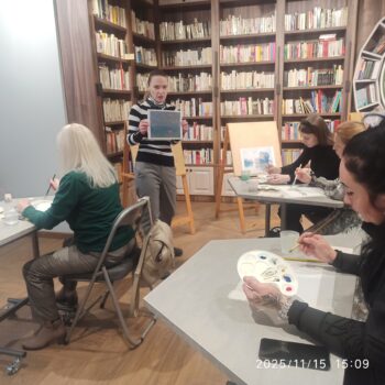 педагог показывает картину и публика рисует