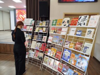 девушка смотрит книгу на выставке